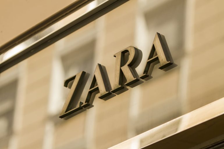 Zara's logo in gold across a storefront