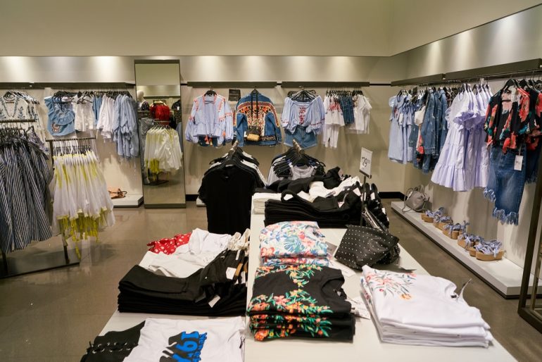 Inside of a Zara store, clothes on racks and on display