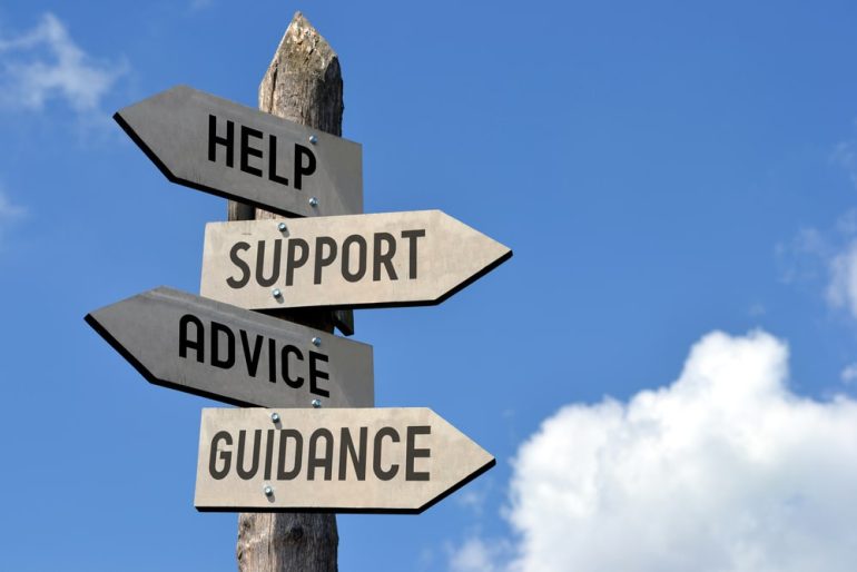 Wooden signposts with help, support, advice and guidance written on them
