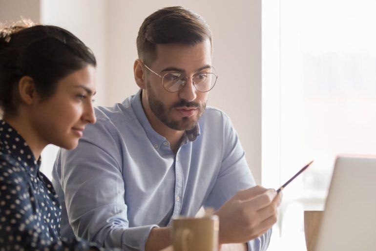 Man teaching a woman how to use post-edit machine translations